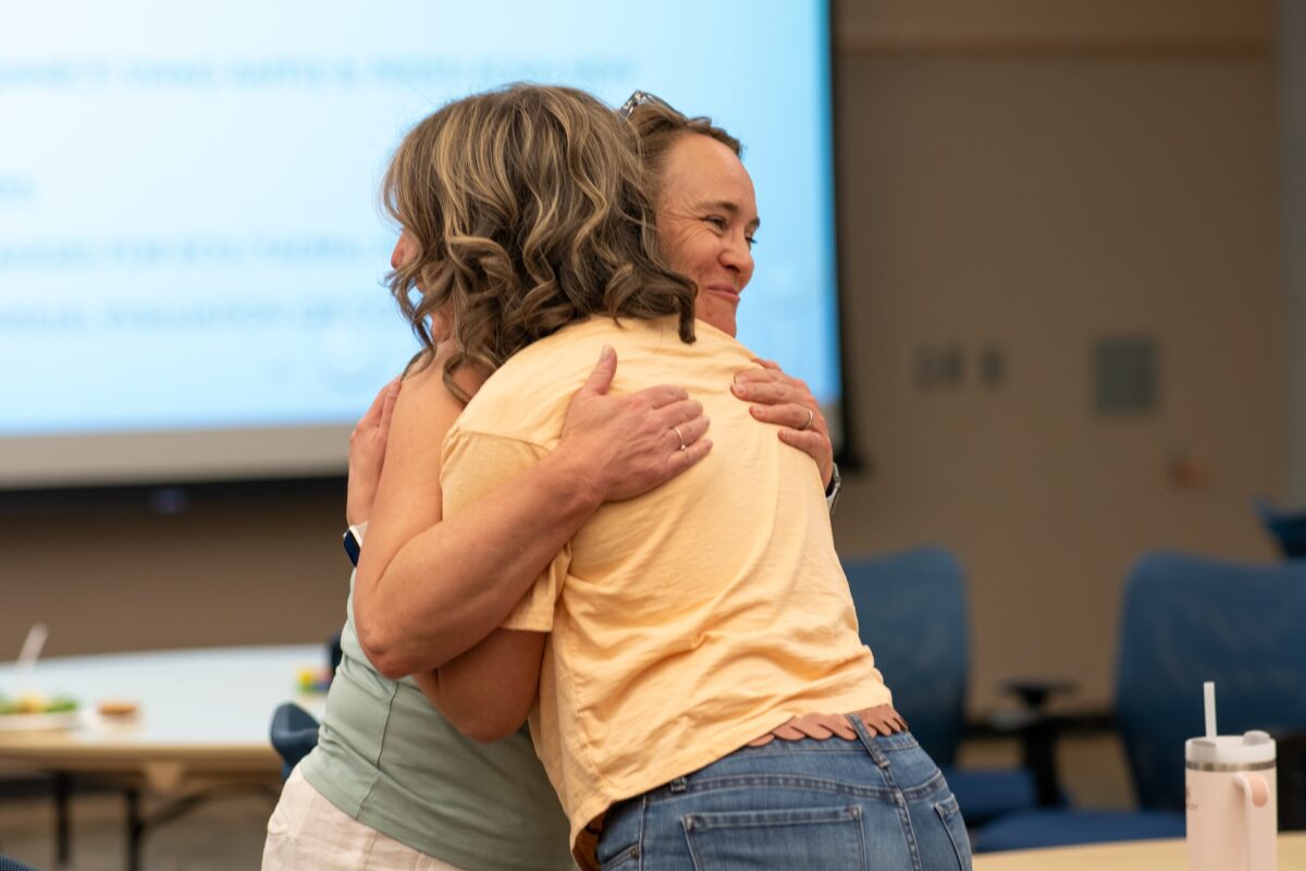 Two early childhood providers hugging each other