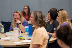 A group of early childhood providers smiling and participating in a discussion