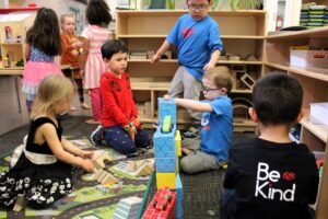 Group of children playing with building blocks on the carpet